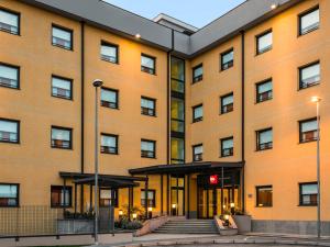 a large orange building with a staircase in front of it at Hotel Ibis Milano Malpensa in Cardano al Campo
