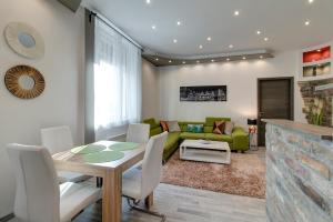 - un salon avec une table et un canapé vert dans l'établissement Tamara Apartment, à Budapest