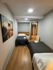 a room with two beds and a painting on the wall at PASEO ROMANo in Lugo