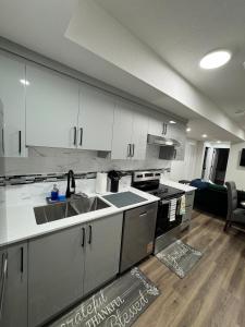a kitchen with white cabinets and a sink at Private Stylish Suite, Just Bring Your Bags in Edmonton