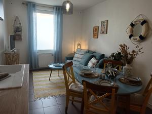 a living room with a table and a couch at Le Ptit Balu, Appartement en ville, proche de Bordeaux in Bègles