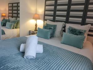 a bedroom with two beds with blue and white pillows at Le Ptit Balu, Appartement en ville, proche de Bordeaux in Bègles