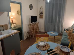 a kitchen and a living room with a table at Le Ptit Balu, Appartement en ville, proche de Bordeaux in Bègles