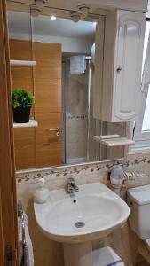 a bathroom with a white sink and a toilet at PASEO ROMANo in Lugo +62 photos