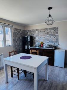 a kitchen with a white table in a room at Brumas Patagónicas in El Chalten