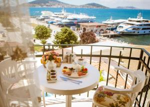 a table with food on a balcony with a view of a harbor at Buyukada Princess Hotel in Buyukada