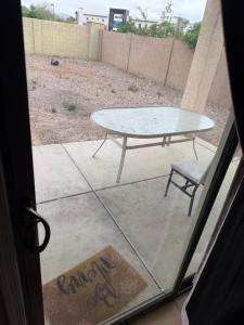 a table and a chair outside a door at Goodyear Cul-de-sac Room 5 in Goodyear
