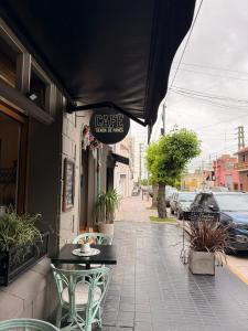 a cafe with a table and chairs on a sidewalk at La Josefina Hotel Boutique in Olavarría