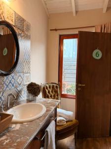 a bathroom with a sink and a mirror at La Josefina Hotel Boutique in Olavarría