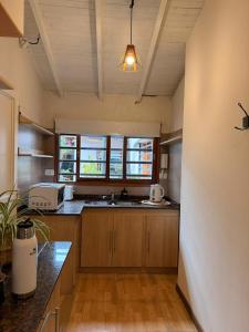 a large kitchen with wooden cabinets and a window at La Josefina Hotel Boutique in Olavarría +36 photos