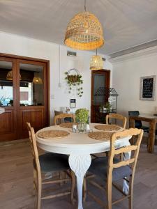 a dining room table with chairs and a chandelier at La Josefina Hotel Boutique in Olavarría