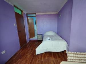a bedroom with purple walls and a bed in it at Inti Ut'ha in Puno +41 photos
