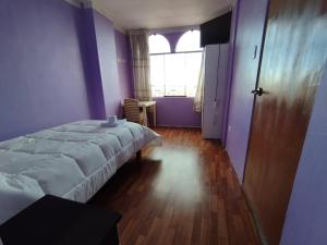 a bedroom with a bed and a large window at Inti Ut'ha in Puno