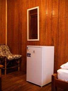 a room with a refrigerator and a window and a chair at Vista do Lago Jungle Lodge in Cajual