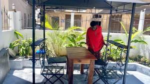 a person standing under a tent with a table and chairs at Nuru House Stone Town Ensuite 3BR Apartment in Zanzibar City
