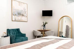 a bedroom with a bed and a chair and a table at Cove Studios in Byron Bay