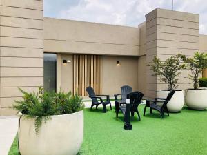 a patio with chairs and tables on the grass at GV Aparta Suites - Centro Chía in Chía +139 photos