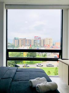 a large window in a bedroom with a large bed at GV Aparta Suites - Centro Chía in Chía