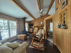 a living room with wooden walls and a ceiling at Le Chouette Chalet in La Malbaie