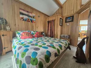 a bedroom with a bed with a colorful comforter at Le Chouette Chalet in La Malbaie