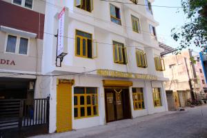 a building with yellow doors and windows on a street at Aruppukottai Nadar Lodge in Chennai