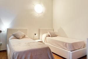 ヴェローナにあるMaison de Amelieのベッドルーム1室(ベッド2台付)、壁に照明が備わります。