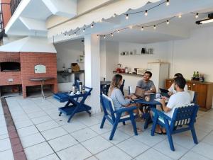 a group of people sitting at a table with laptops at Cantinho no litoral a 100mts da praia in São Sebastião