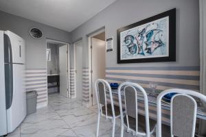 a kitchen with striped walls and a table with chairs at Pequeno Paraíso Flats Praia Bela in Pitimbu +69 photos