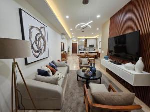 a living room with couches and a flat screen tv at Brisamar La Paz- Terraza Vista al Mar - Cerca del Malecon in La Paz