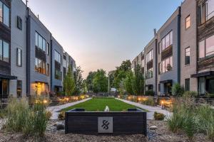 a courtyard with a sign in front of some buildings at Modern Townhome Near Downtown walk to CWS! in Omaha