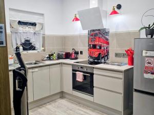 a kitchen with a red double decker bus on the wall at ApArt 2 Luxury 3BR Apartment Free Parking Sleeps 6 in Bedford