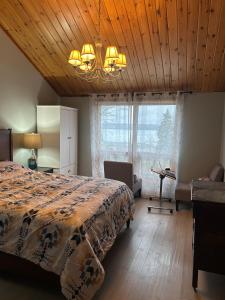 a bedroom with a bed and a wooden ceiling at Chalet Style, Lakeview Cottage in Bailieboro
