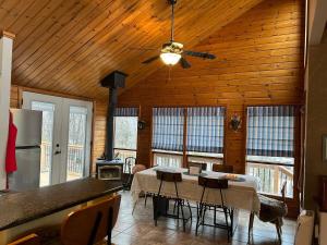 a kitchen and dining room with a table and a ceiling at Chalet Style, Lakeview Cottage in Bailieboro