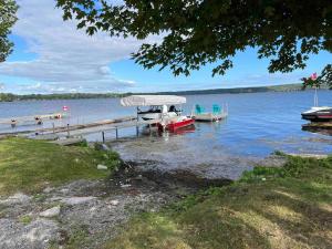 a boat is docked at a dock on a lake at Chalet Style, Lakeview Cottage in Bailieboro