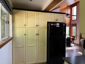 a kitchen with a black refrigerator and some cabinets at Chalet Style, Lakeview Cottage in Bailieboro