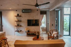 a living room with a couch and a ceiling fan at Villa Camila Tulum in Tulum