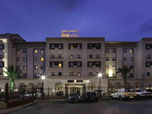 a hotel with cars parked in a parking lot at Ibis Constantine in Constantine