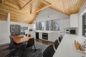a kitchen with white cabinets and a wooden ceiling at Baernhaus in Government Camp