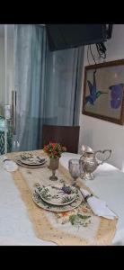 a table with plates and bowls on top of it at Pousada Brasil Tropical in Bezerros +27 photos