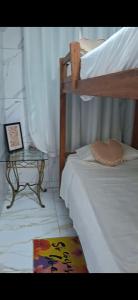a bedroom with a bunk bed and a side table at Pousada Brasil Tropical in Bezerros