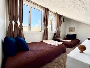 two beds in a room with two windows at Eagles Roost Haven - Cozy Ski View Condo in Brian Head