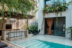a house with a swimming pool and a hammock at Villa Camila Tulum in Tulum