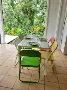 a table with chairs and glasses on it on a porch at bungallow T2 Vernou in Petit-Bourg