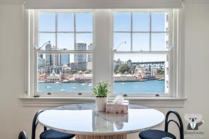 a table and chairs in a room with a window at KozyGuru | MacMahons Point | Harbour Hideaway in Sydney
