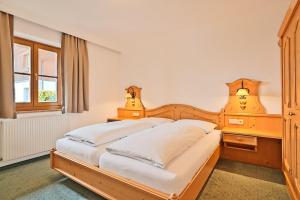 a bedroom with a wooden bed and a window at Appartementhaus Alpenpark in Grossarl