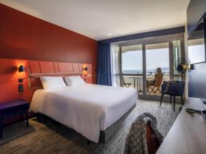 a hotel room with a large bed and a balcony at Mercure Thalasso & Spa Port Fréjus in Fréjus +103 photos