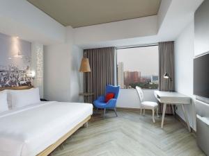 a hotel room with a bed and a desk and chairs at Mercure Jakarta Simatupang in Jakarta +159 photos