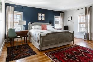 a bedroom with a bed and a desk and a bed sidx sidx sidx at The Lindsey Hotel in Rockland