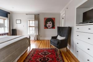 a bedroom with a bed and a chair at The Lindsey Hotel in Rockland