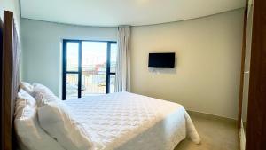 a bedroom with a white bed and a tv at Essenza Living in Formosa